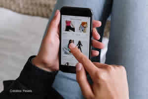 Una persona recostada mirando una tienda en su celular